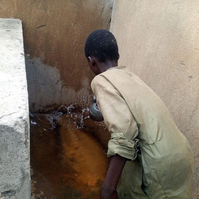 Mustapha Waje, a boy washing off his faeces into drainage at a Motor Park, Dutse. Photo Credit: Sunday Awosoro/DUBAWA